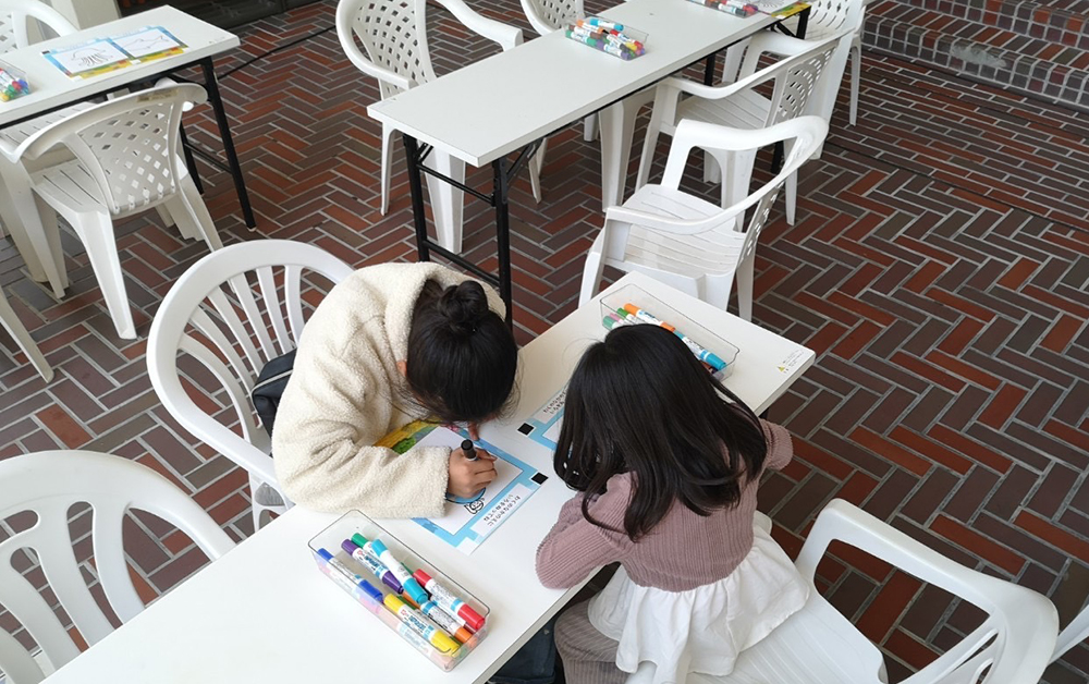 白いテーブルの上でぬりえをする子ども２人