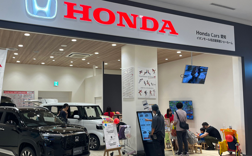 車のショールームの一角でおえかきパラダイスペーパークラフトを楽しむ親子